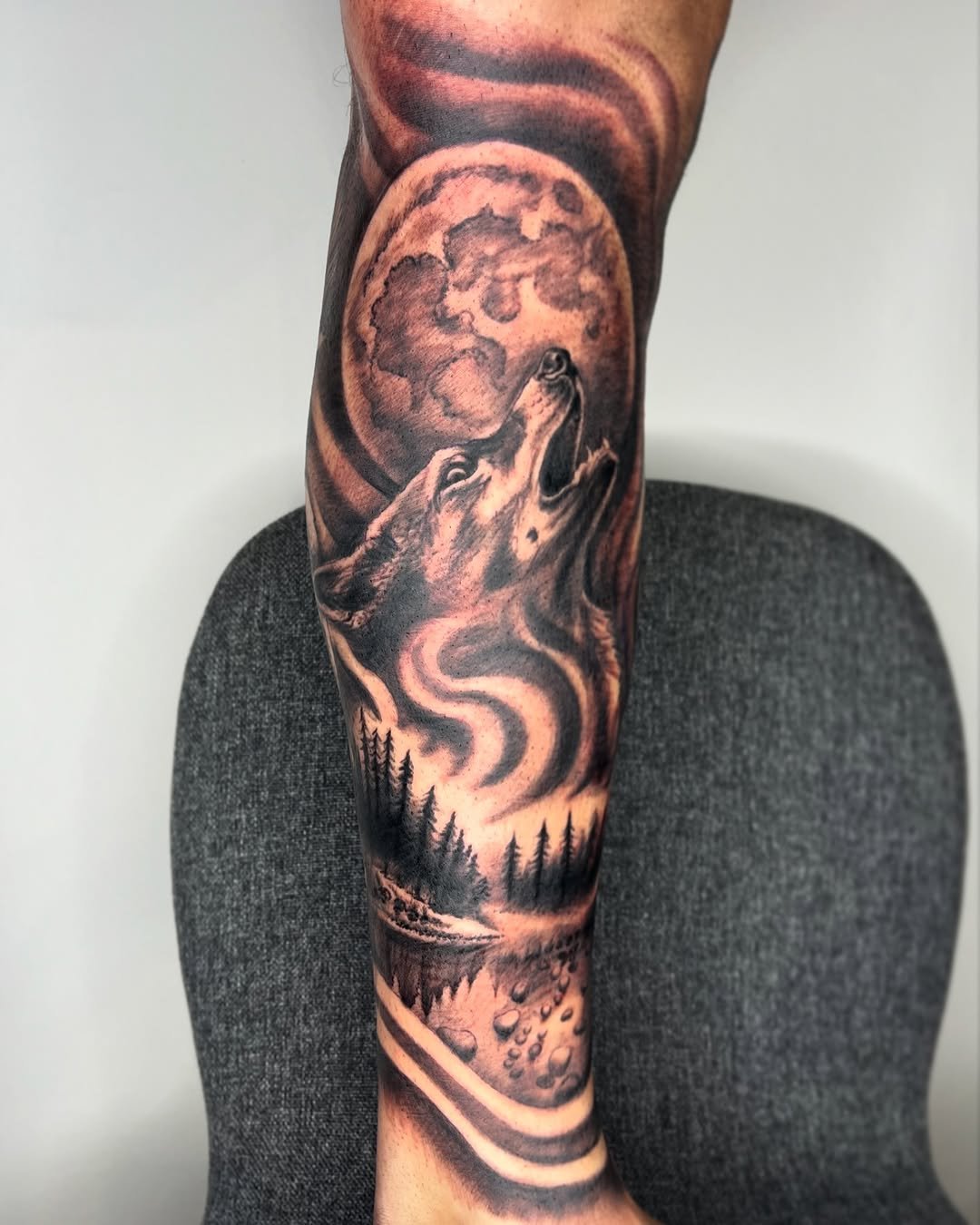 Tatuaje profesional en estudio MartinK Tattoo de un lobo aullando a la luna