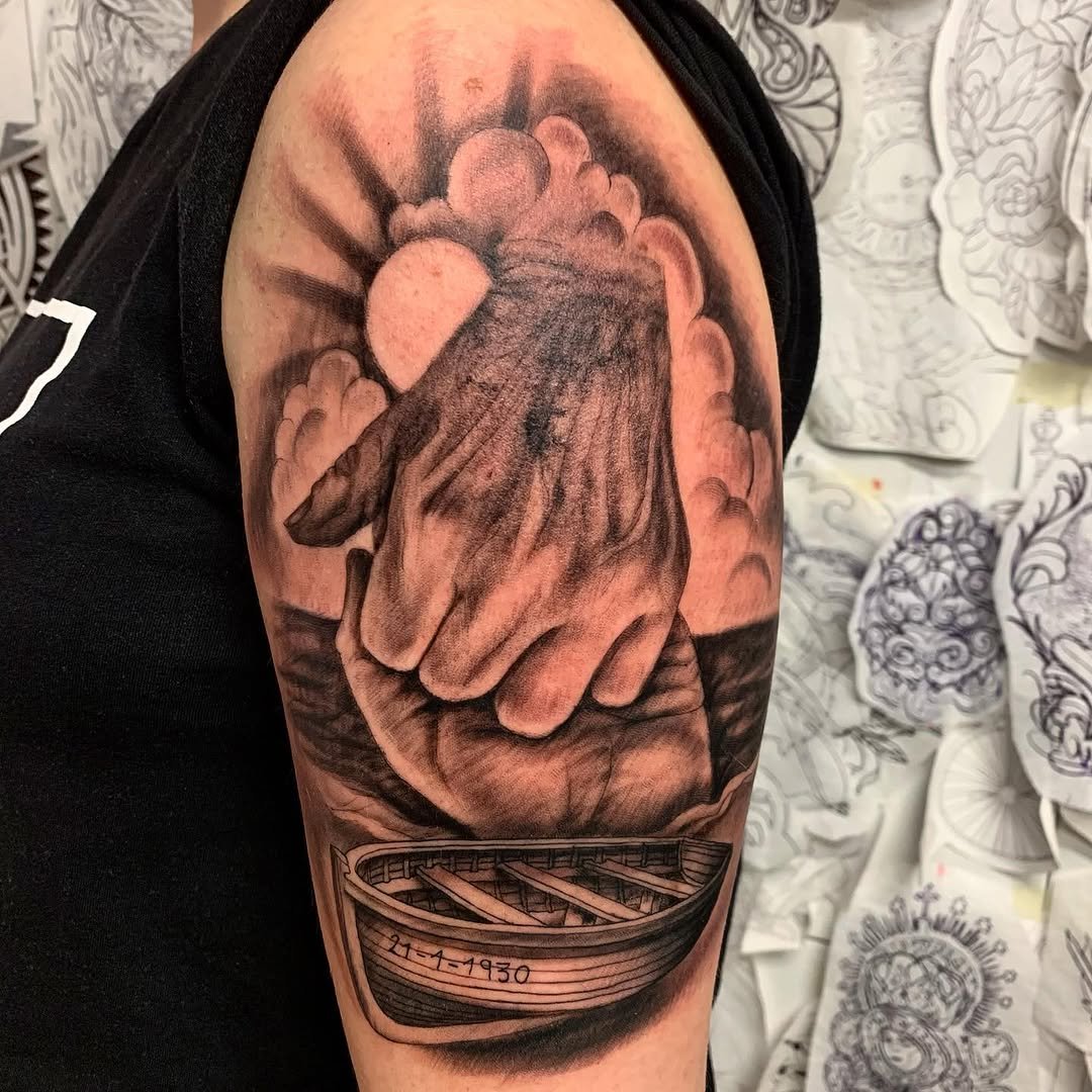 Tatuaje profesional en estudio MartinK Tattoo de unas manos y una barca en la orilla