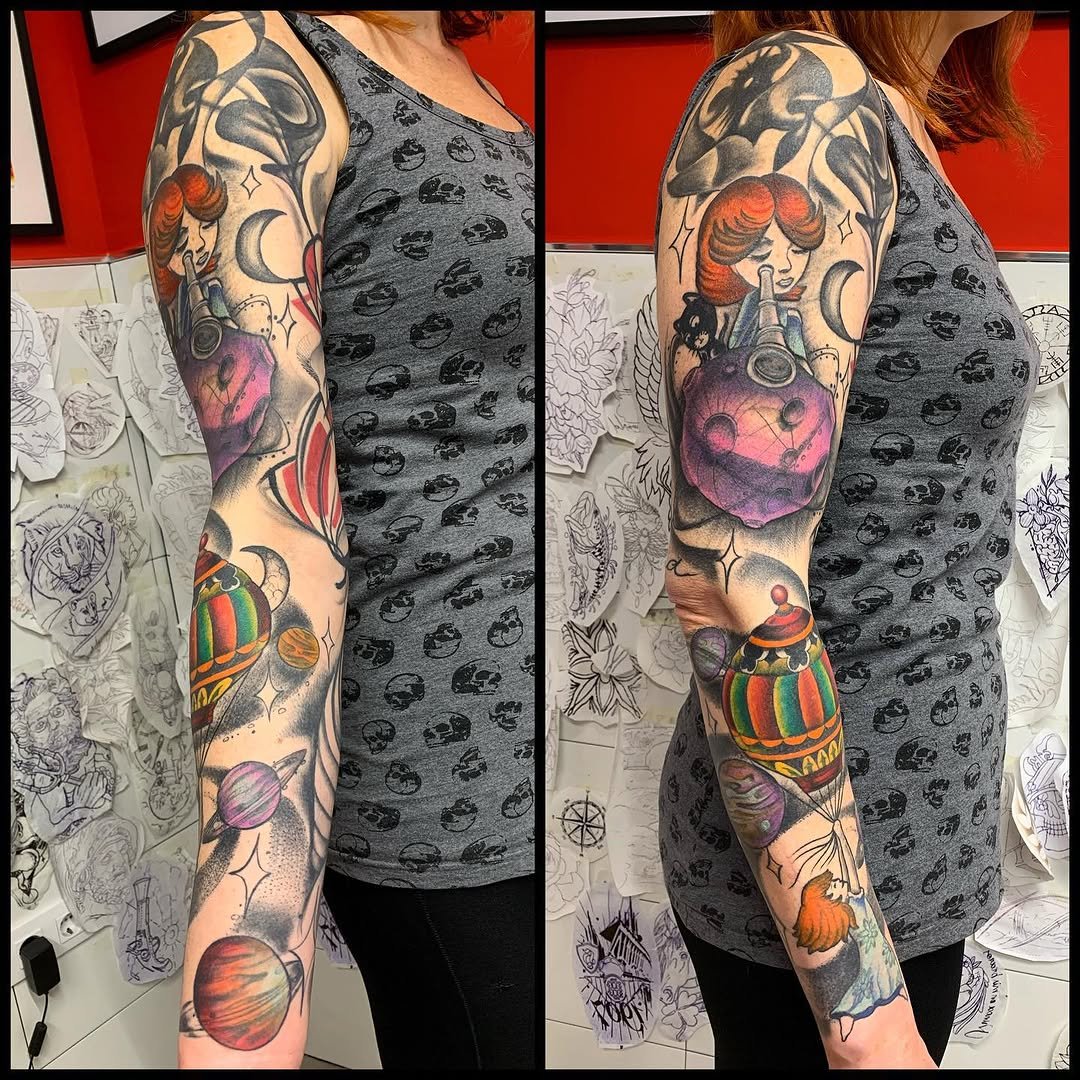 Tatuaje profesional en estudio MartinK Tattoo manga con globo, planetas, niña y luna