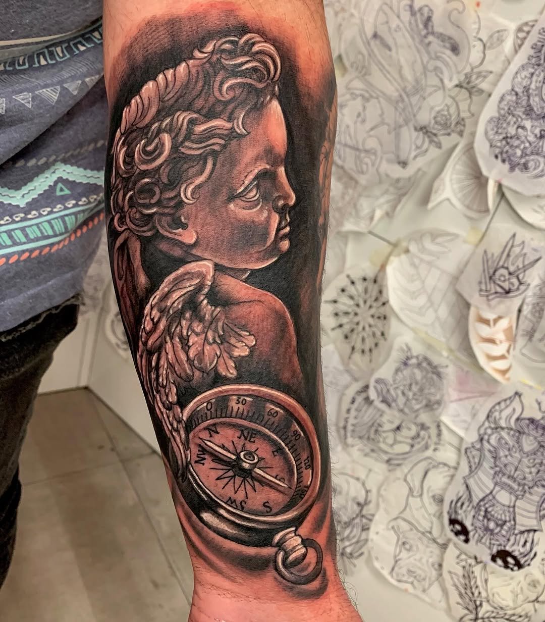 Tatuaje profesional en estudio MartinK Tattoo de un ángel con un reloj